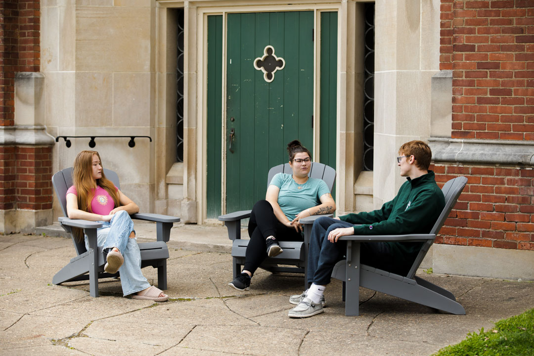 Students sitting in front of Phillips Hall talking