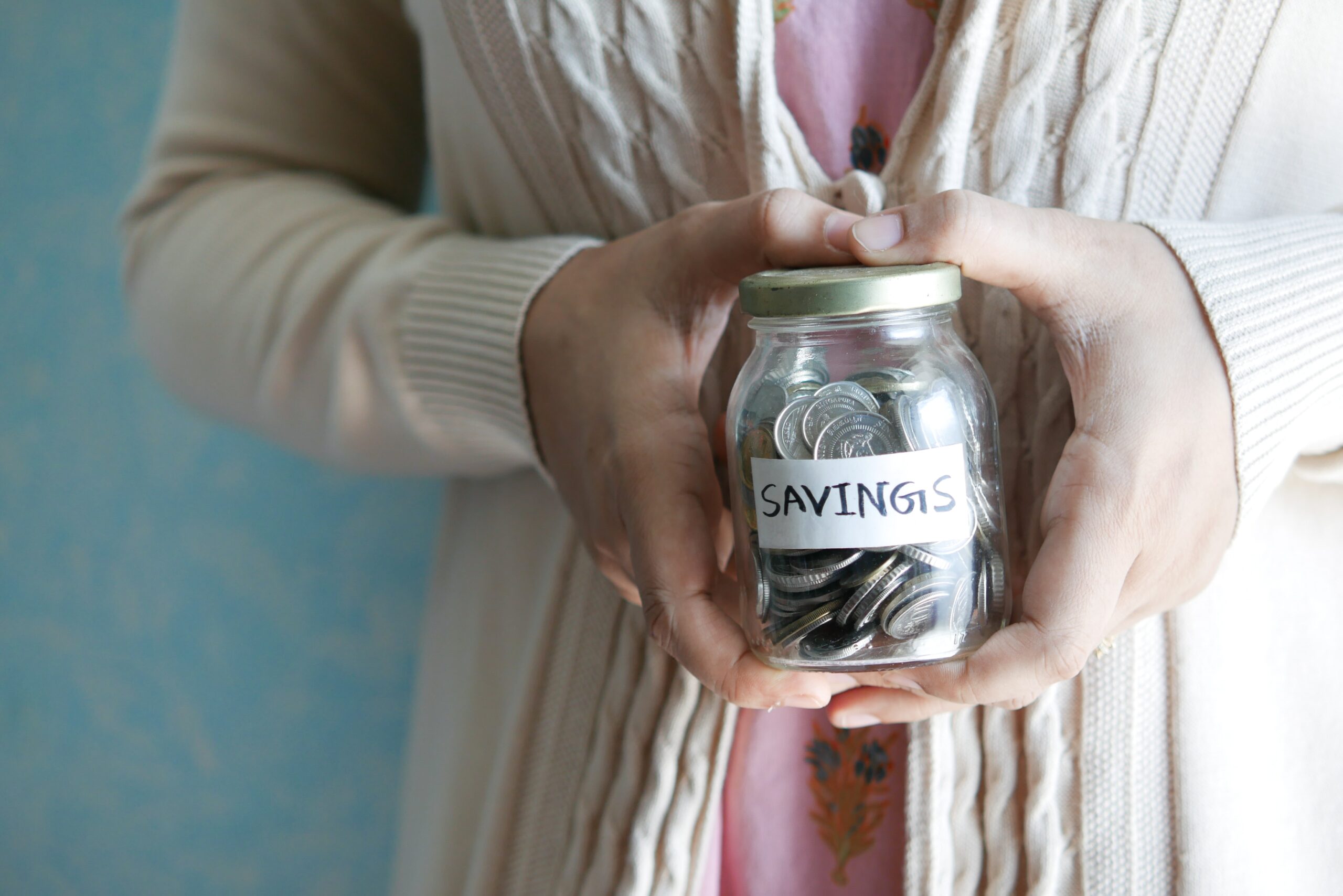 person holding jar of joins labeled savings