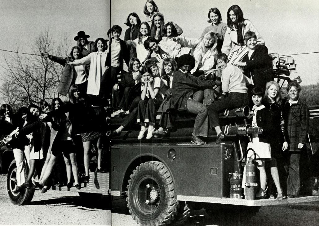 yearbook photo from the past with students on fire truck in black in white