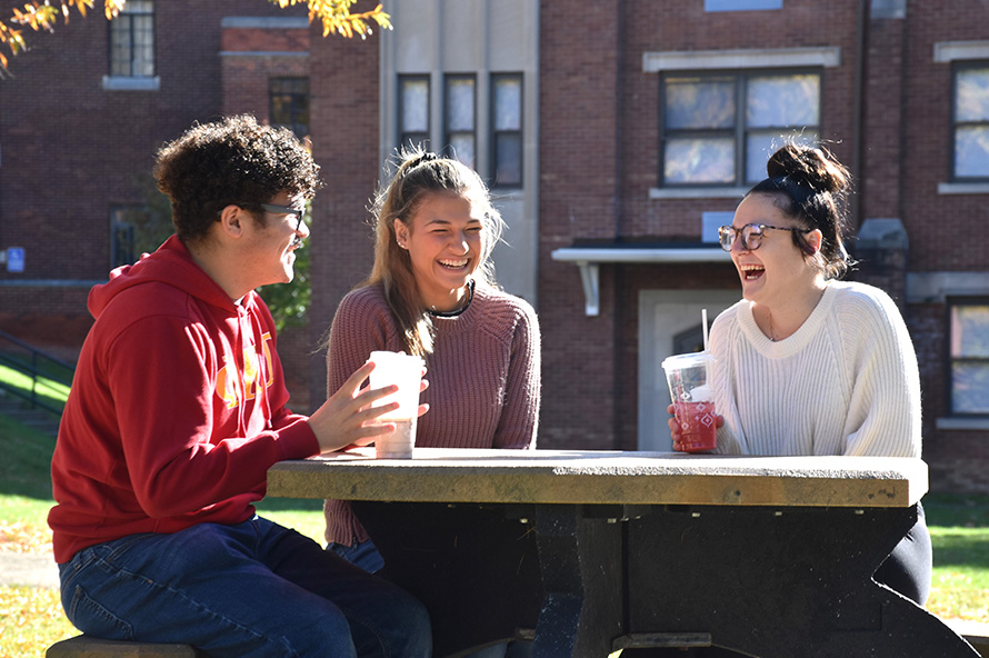 students talking on a bench outdoors